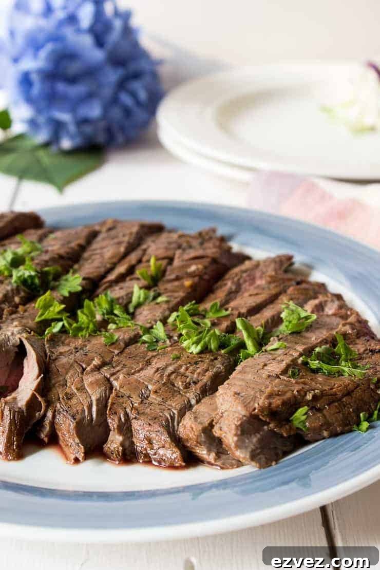 Perfectly Grilled Flank Steak: Juicy Marinade & Sear Guide 2 Slice flank steak on a blue and white plate.