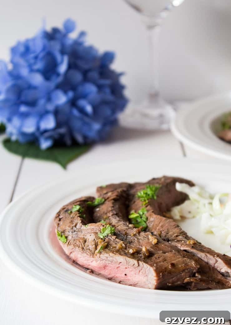 Perfectly Grilled Flank Steak: Juicy Marinade & Sear Guide 3 A plate with sliced steak topped with green parsley.