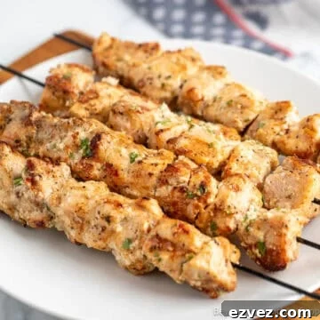 Garlic Parmesan Chicken Skewers on a white dinner plate.