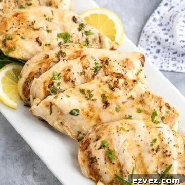 Lemon Herb Chicken with lemon slices on a white plate.