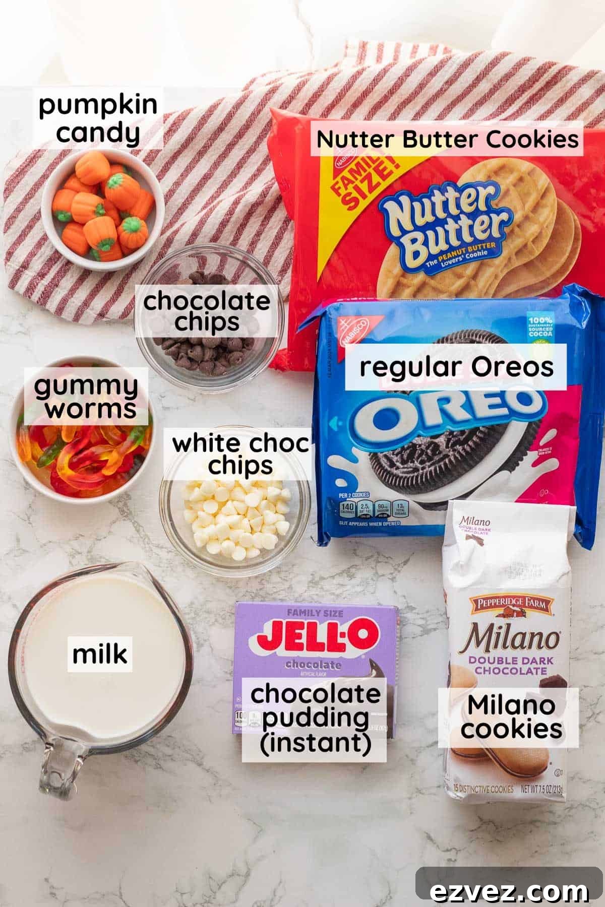 Spooky Halloween Pudding Cups Recipe for Party Treats 3 Labeled ingredients for Halloween Pudding Cups in glass bowls on marble countertop.