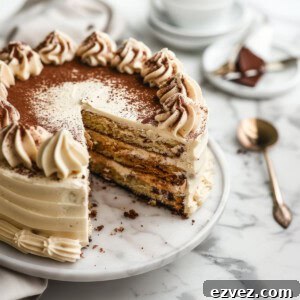 Tiramisu layer cake with frosting and cocoa powder.