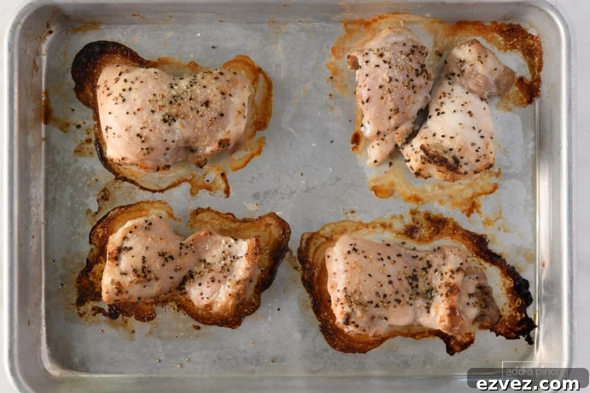 Photo of chicken thighs on a baking sheet.
