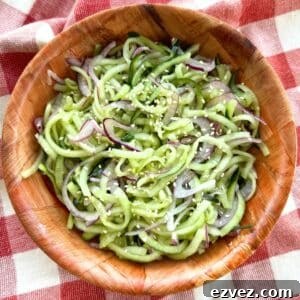 Easy cucumber salad with rice vinegar, red onion and sesame seeds in a brown bowl.
