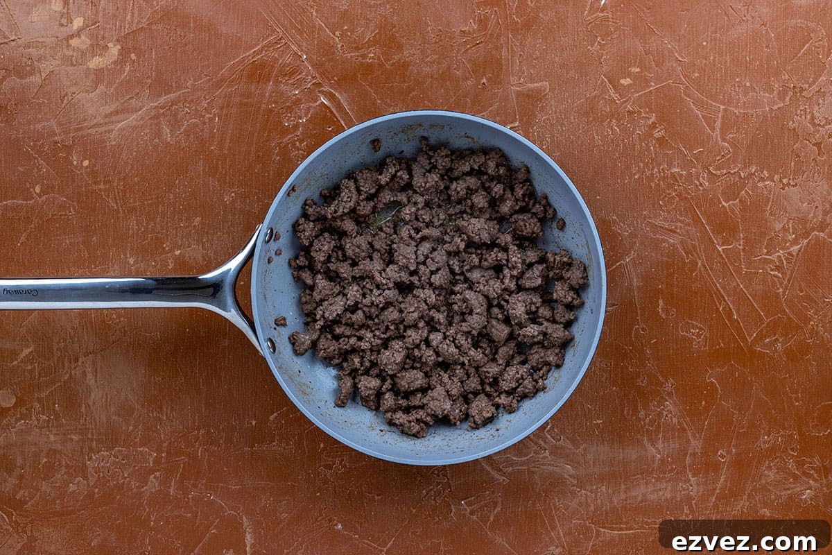 Cooked ground beef in pan.