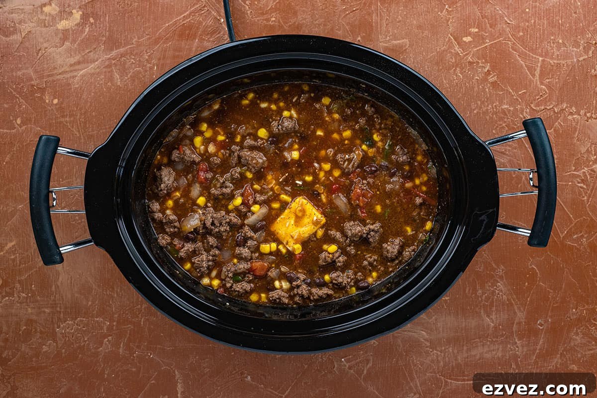 Ground beef, corn, beans and other ingredients in a crockpot.