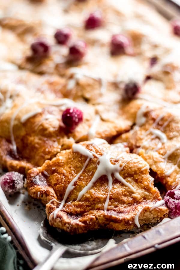 Cranberry apple slab pie with maple glaze on a tray.