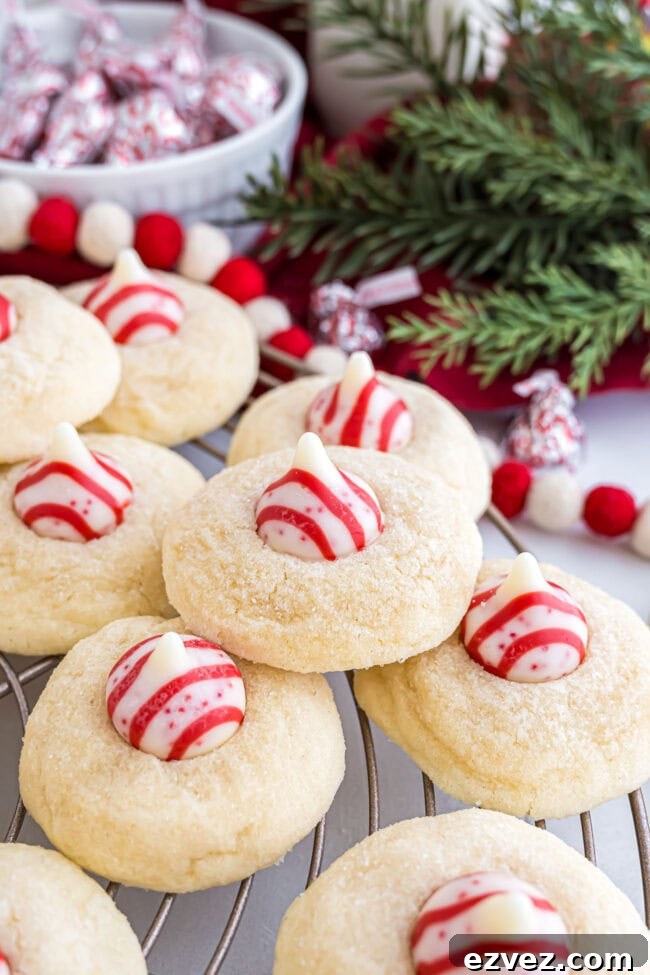 Candy Cane Kiss Cookies cooling on a wire rack, showing the melted peppermint Kisses in the center.