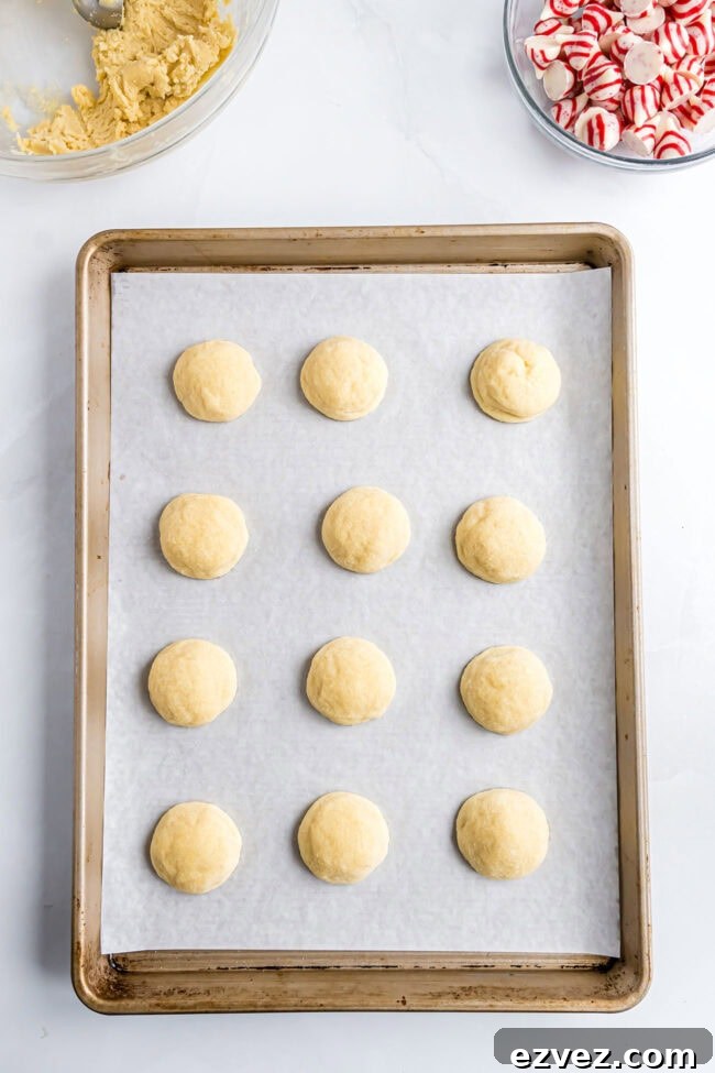 Freshly baked sugar cookies on a sheet pan before adding the Hershey’s Kisses.