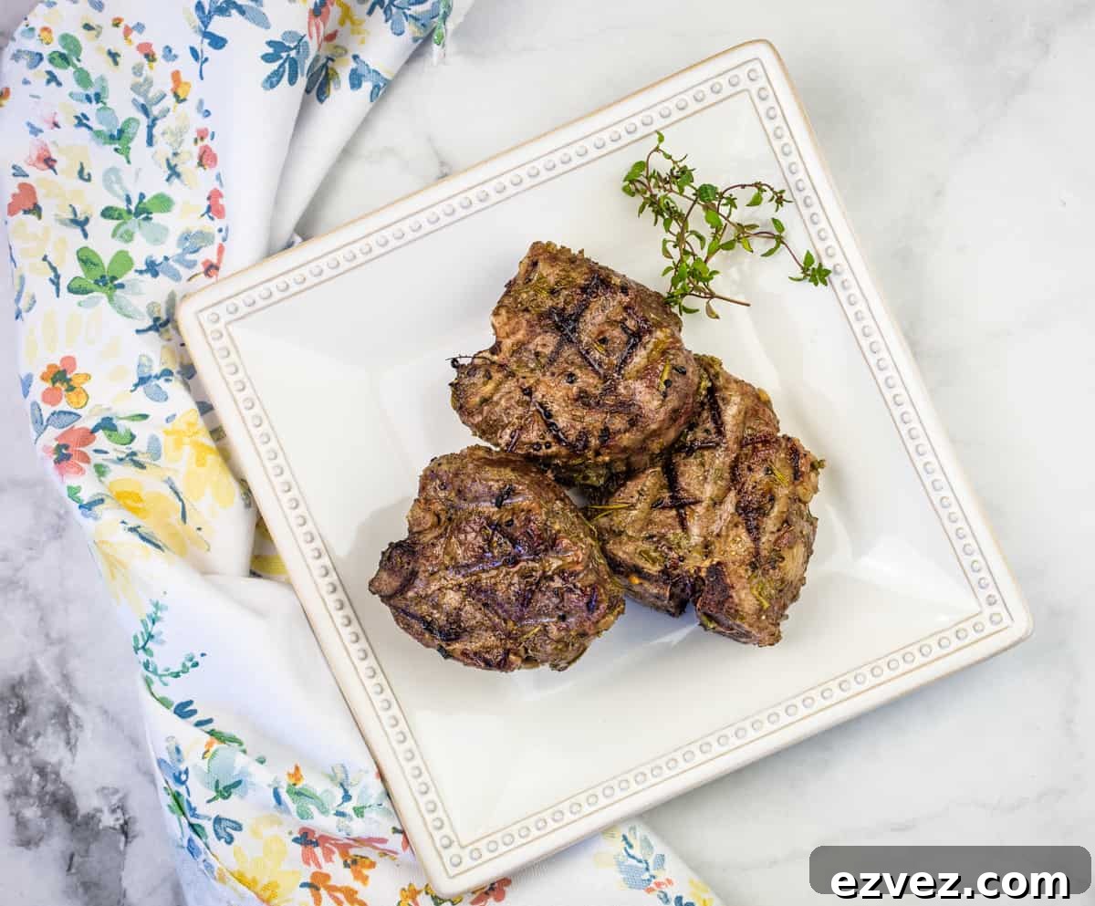 Smoked lamb chops on a white plate with a green napkin.