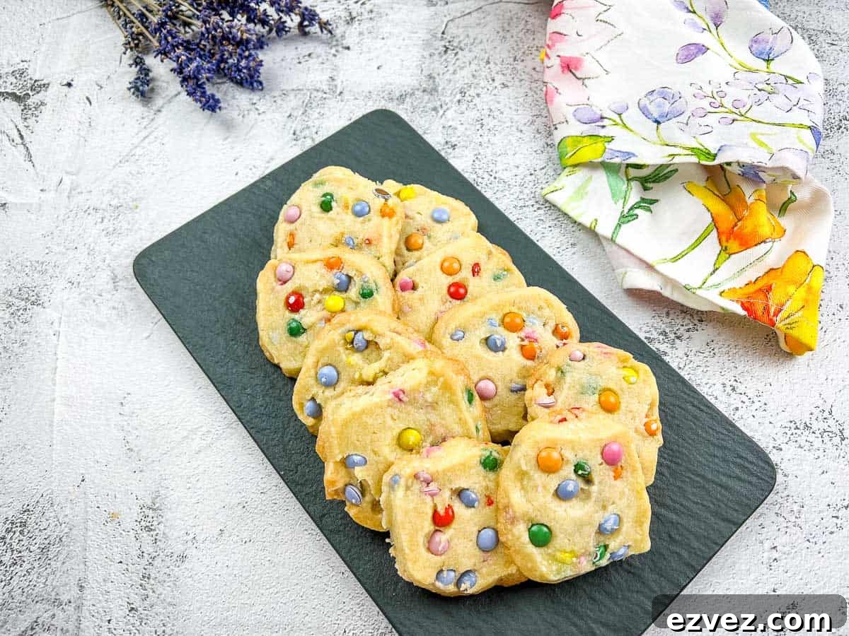 Shortbread M&M cookies on a black slate.