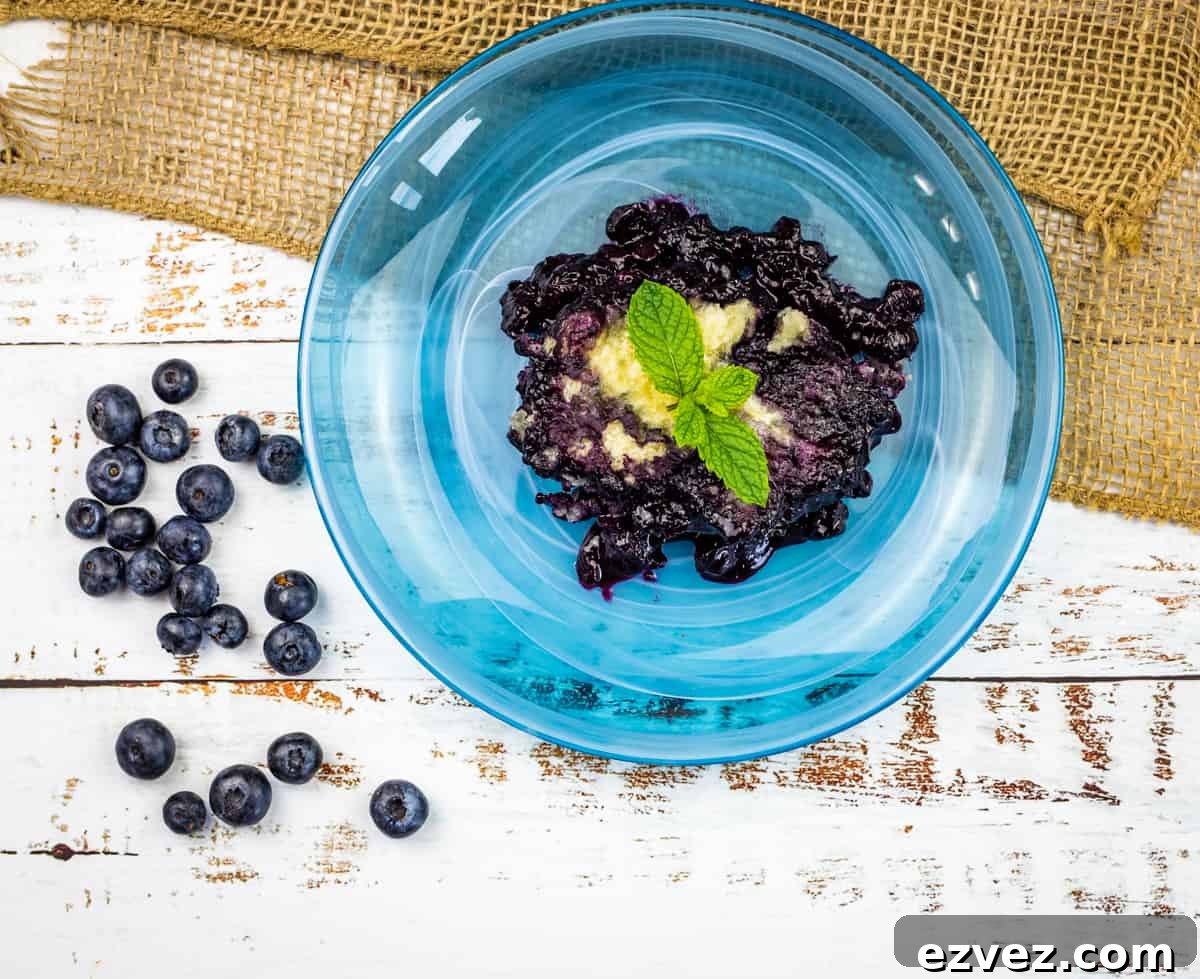 Blueberry Grunt on a blue plate with ice cream.