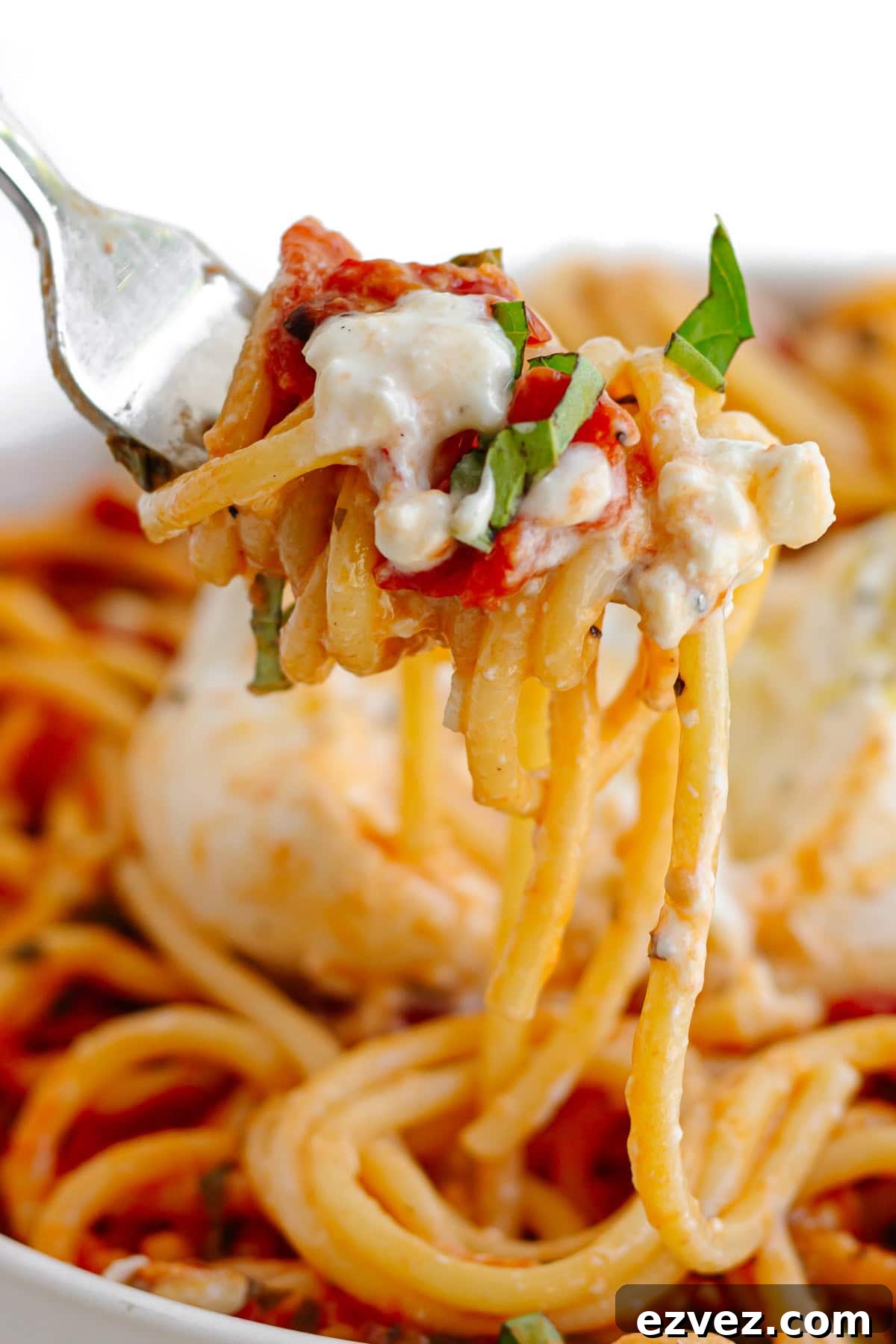 Creamy Burrata Pasta with Cherry Tomato Garlic Butter Sauce 10 Fork lifting up some tomato burrata pasta from plate.