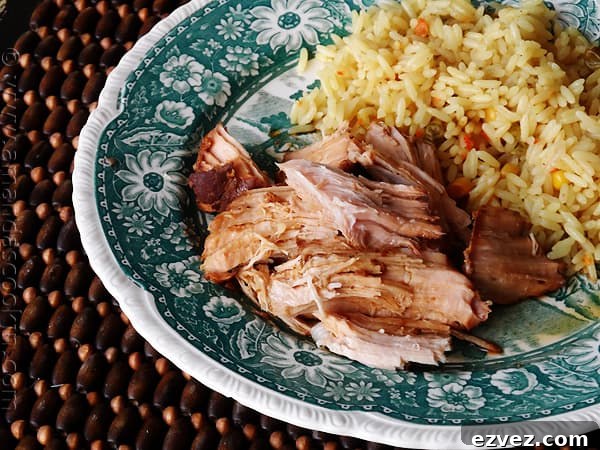 A close up photo of slow cooker oriental pork roast on a plate next to rice.