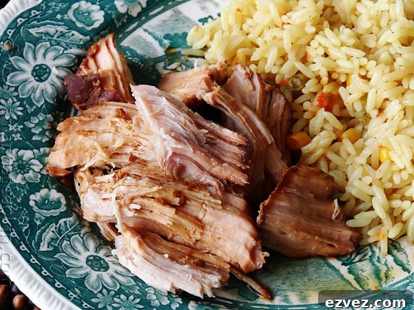 A close up photo of slow cooker oriental pork roast on a plate next to rice.