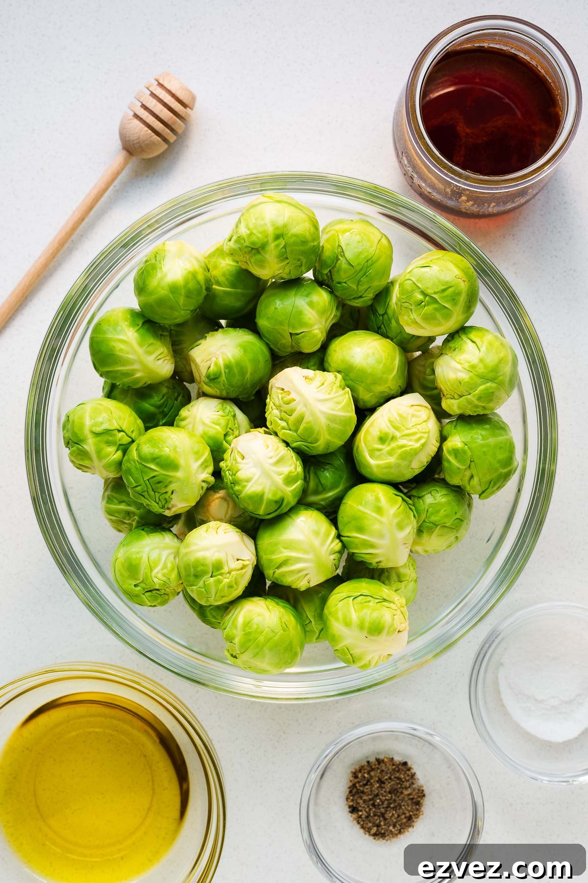 Hot honey Brussels sprouts ingredients arranged in glass bowls and viewed from above.