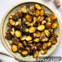 Hot honey roasted Brussels sprouts on a ceramic serving plate viewed from above.