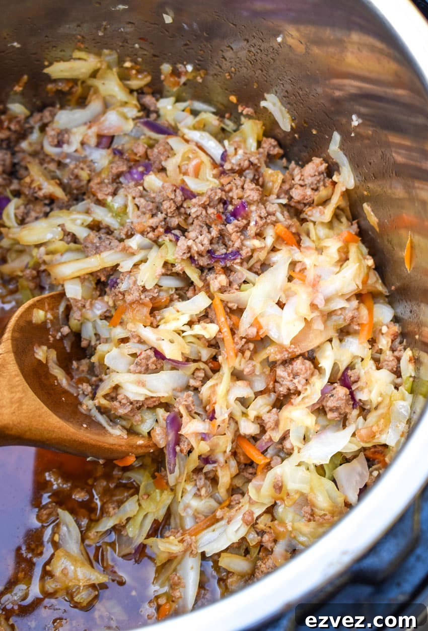 egg roll in a bowl filling in an instant pot with a wooden spoon on the side