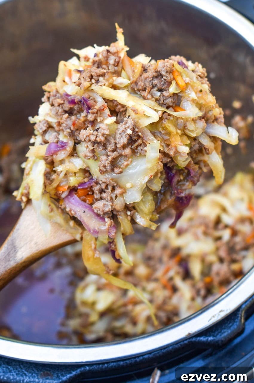 a wooden spoon scooping instant pot egg roll filling out of a pressure cooker