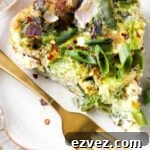 Close up picture of a pie shaped frittata on a plate with a gold fork on top.