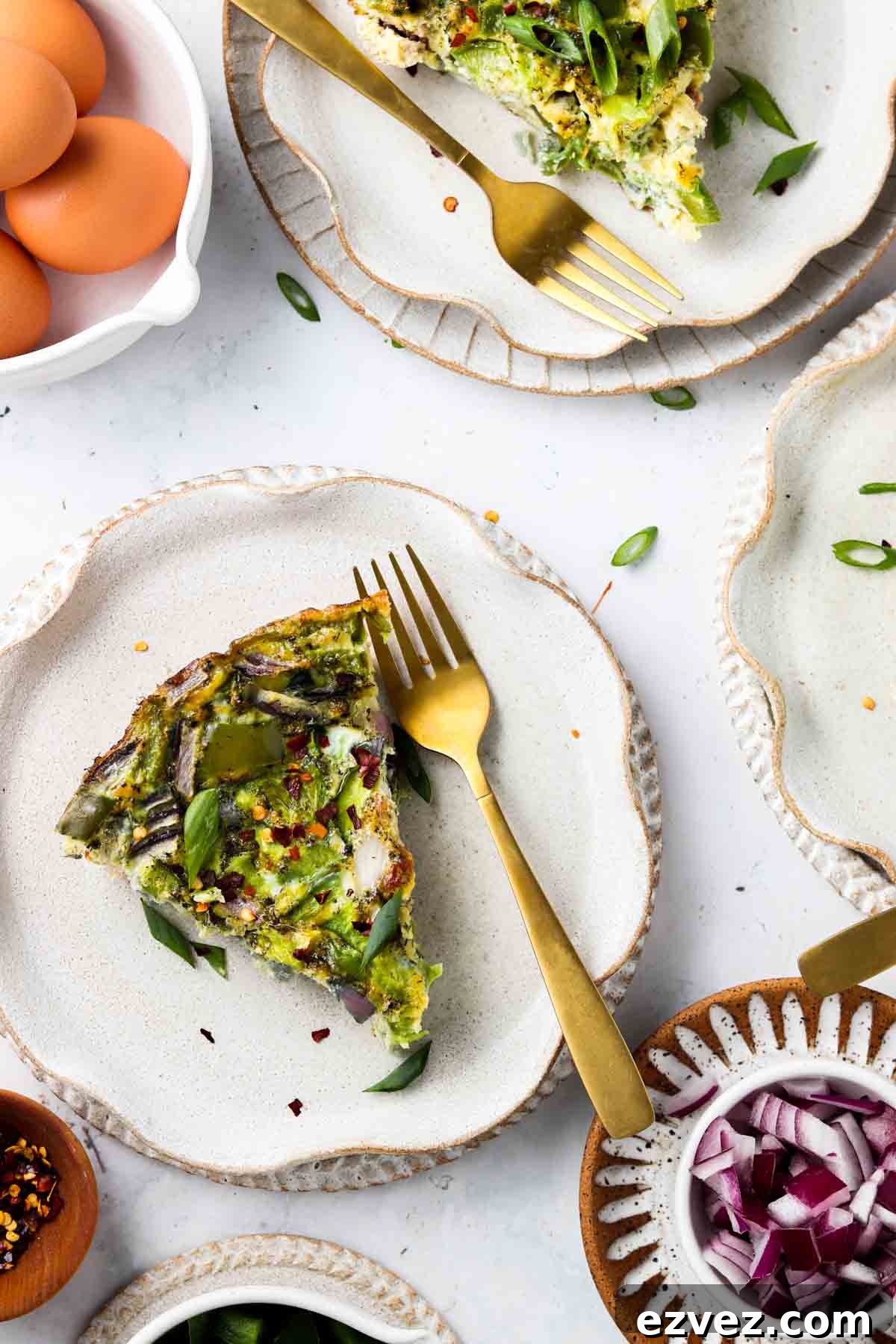 Keto frittata on a plate with a fork and green onions on top.