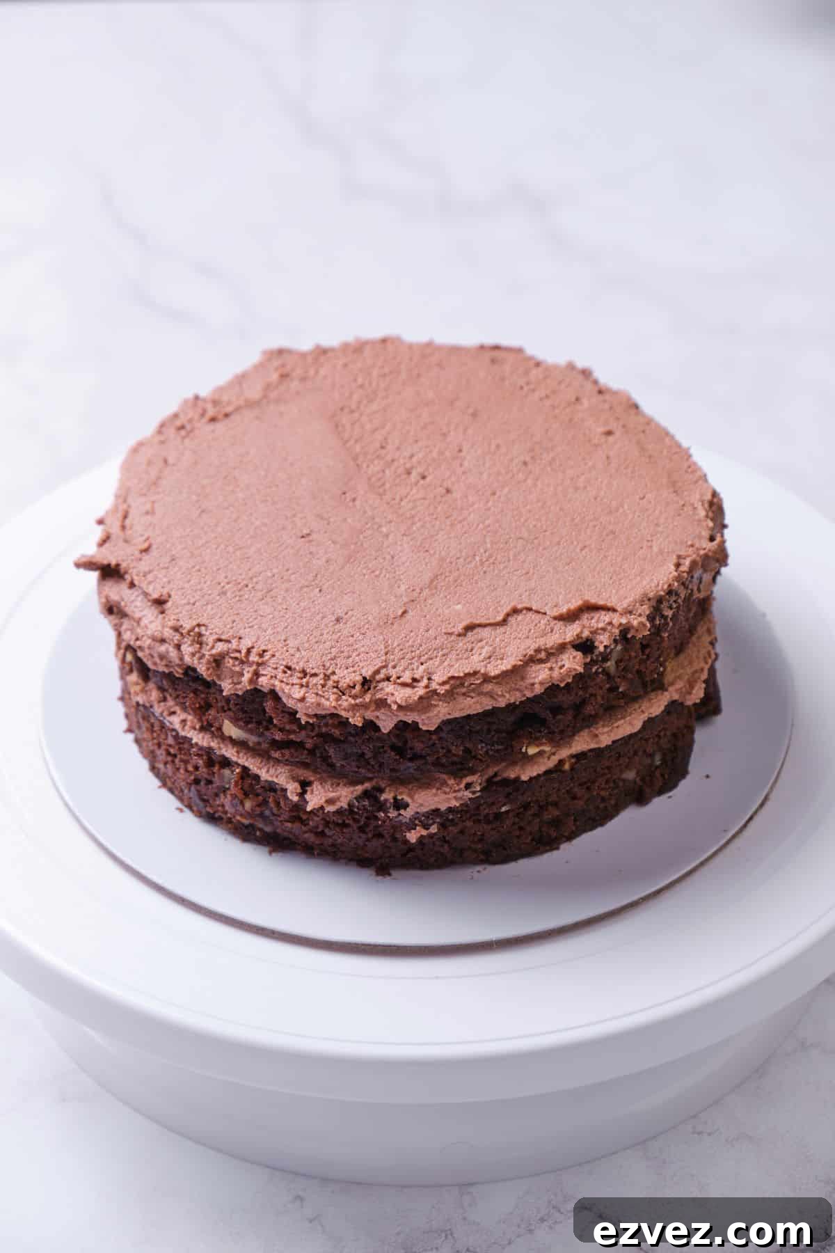 Two layers of a chocolate cake being layered.