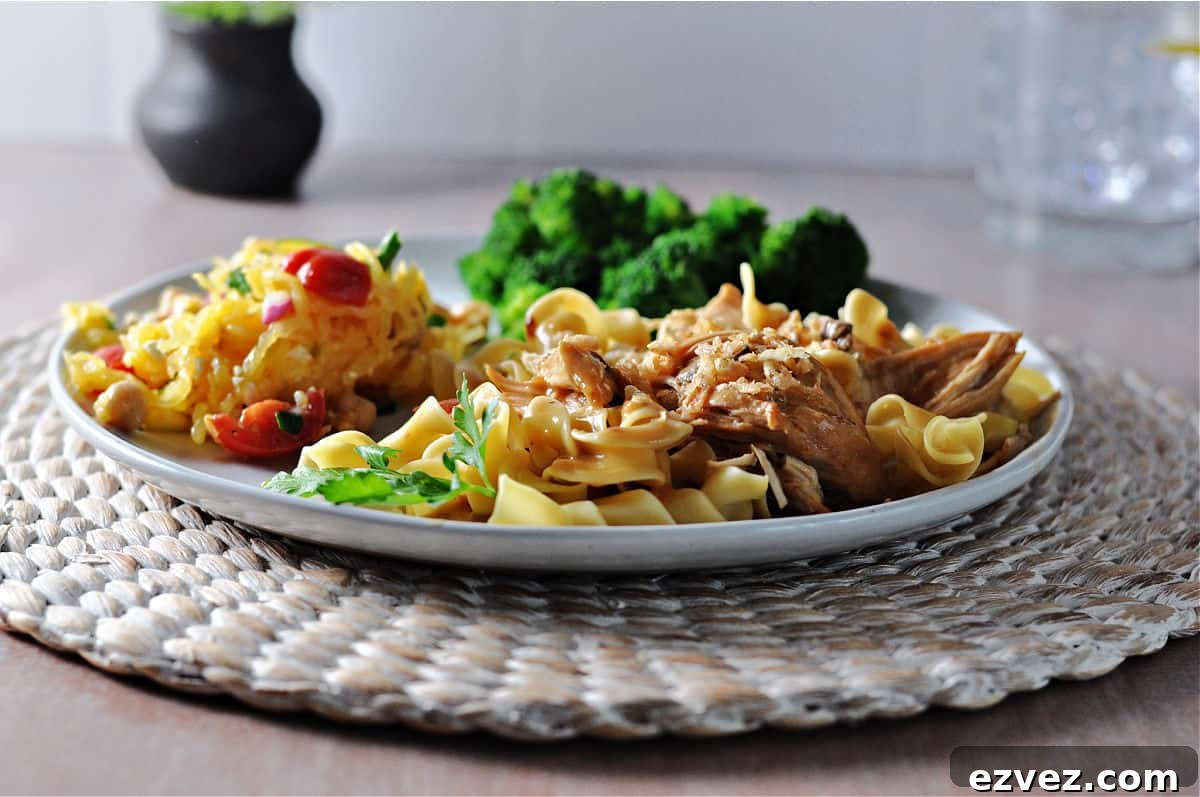Instant Pot French onion chicken on noodles, broccoli and salad behind on the same plate