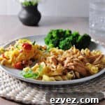 Instant pot french onion chicken with noodles on a plate with broccoli and a salad