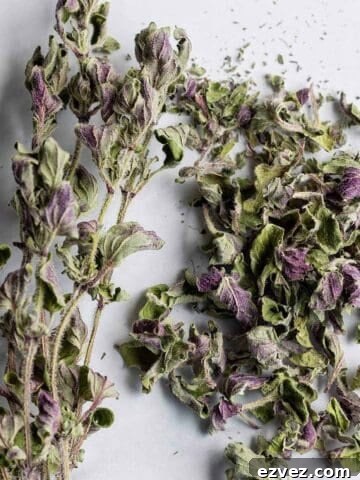 A bundle of dried oregano sprigs and a pile of dried oregano.