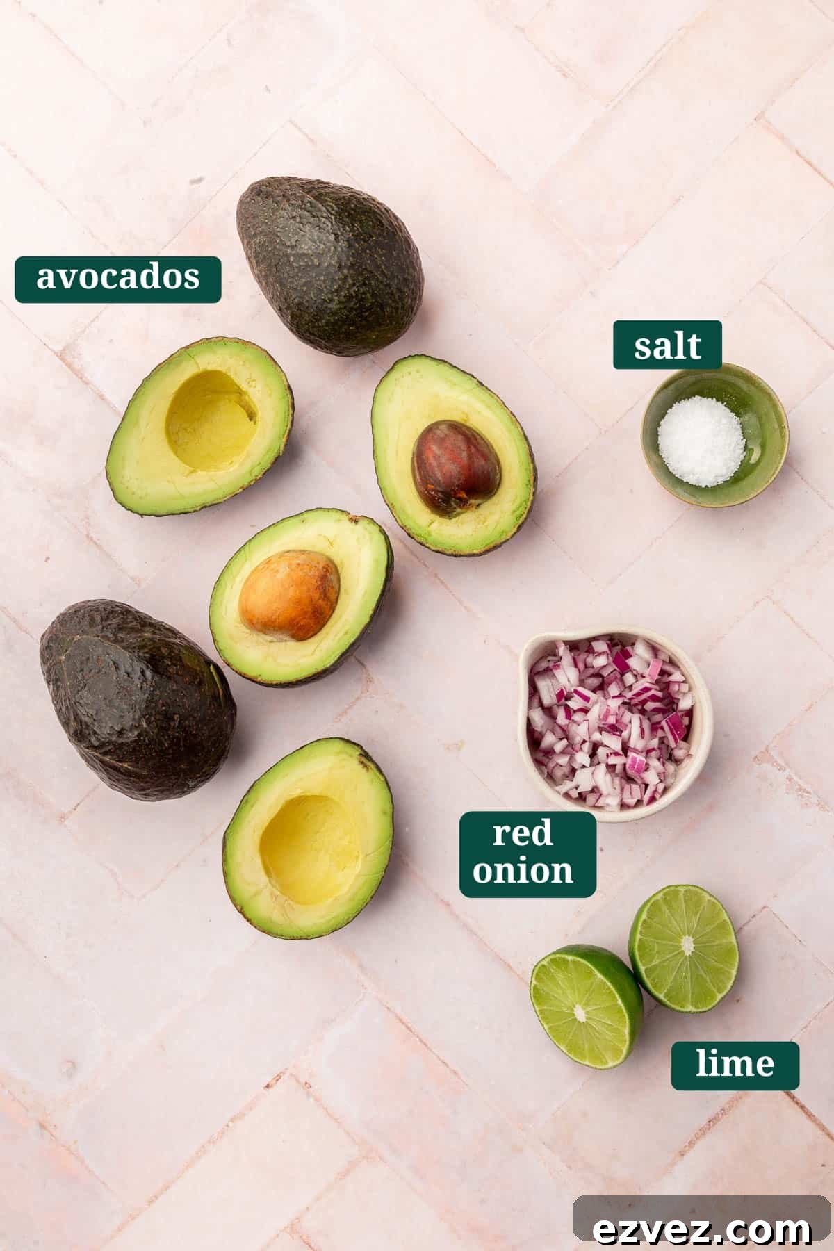 Quick 4-Ingredient Guacamole Recipe 3 Ingredients on a pink table to make guacamole including six avocado halves, a small bowl of kosher salt, a bowl of diced red onion and two lime halves with text overlays over each ingredient saying what it is.