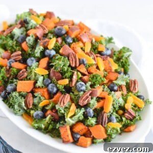 kale salad with sweet potatoes and quinoa on top.