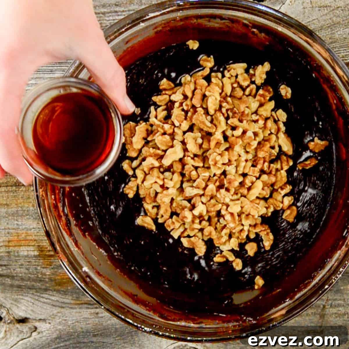 Adding walnuts and vanilla to fudge.
