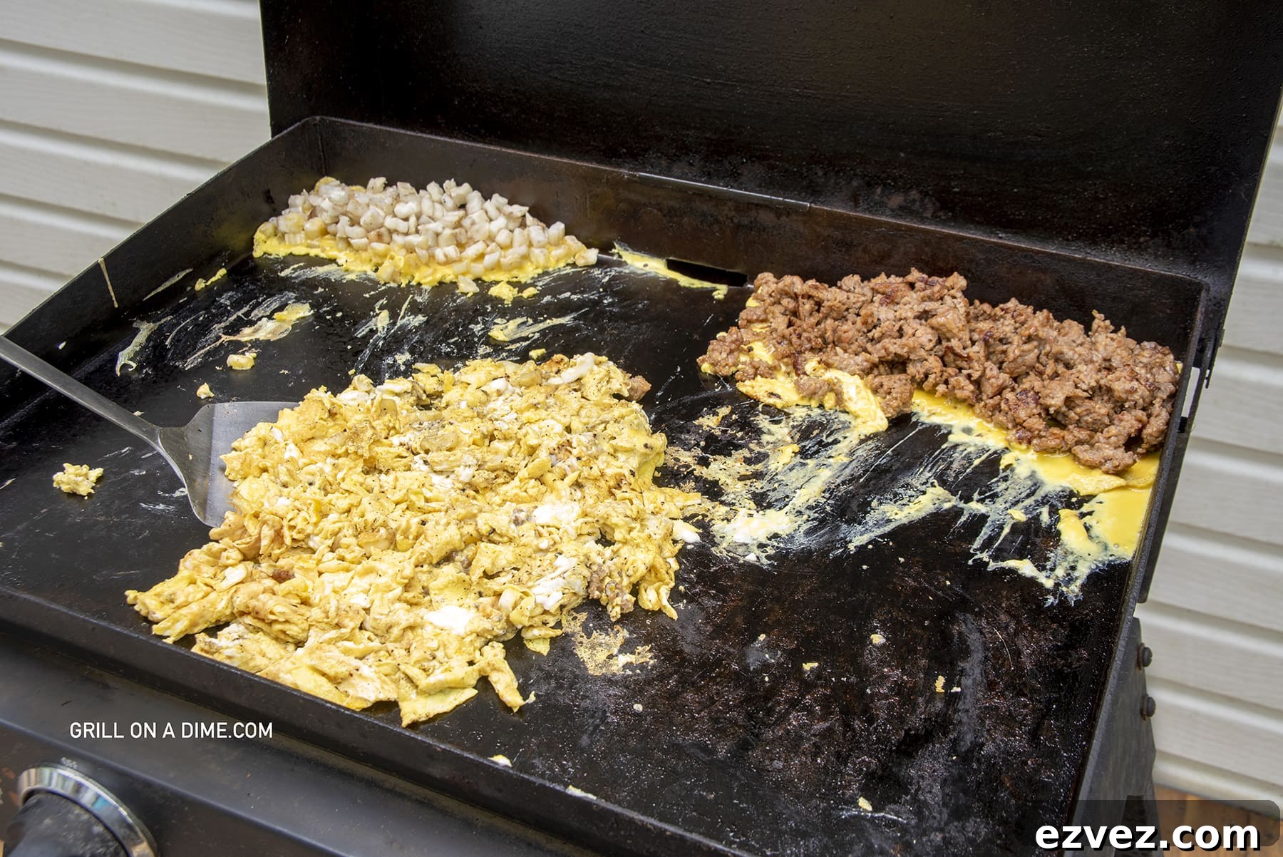 Scramble eggs with cooked hashbrowns and cooked sausage on the griddle