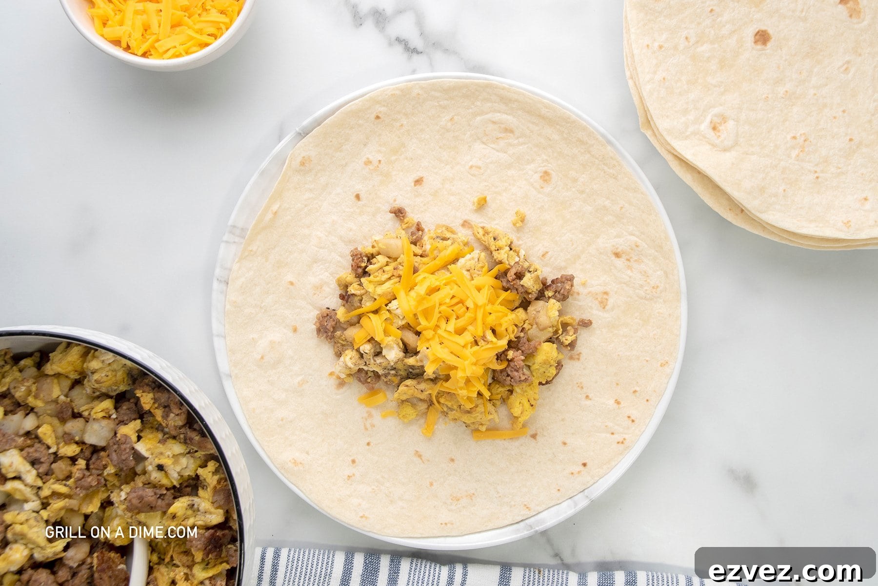 Tortilla on a plate topped with cooked sausage, eggs, and shredded cheese