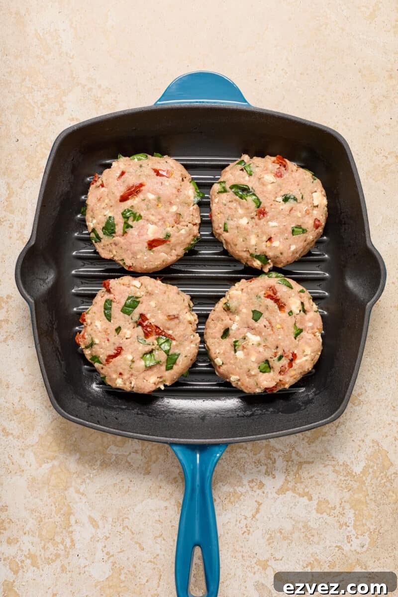 Spinach feta turkey burgers in grill skillet.