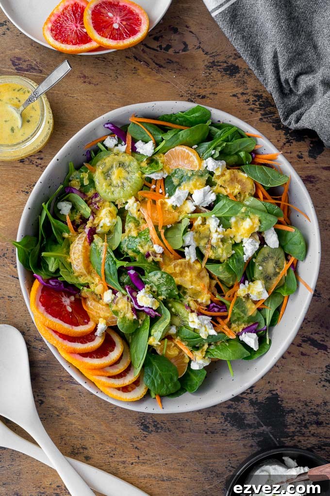 Overhead view of Winter Salad in a large grey bowl topped with Citrus Honey Dressing.