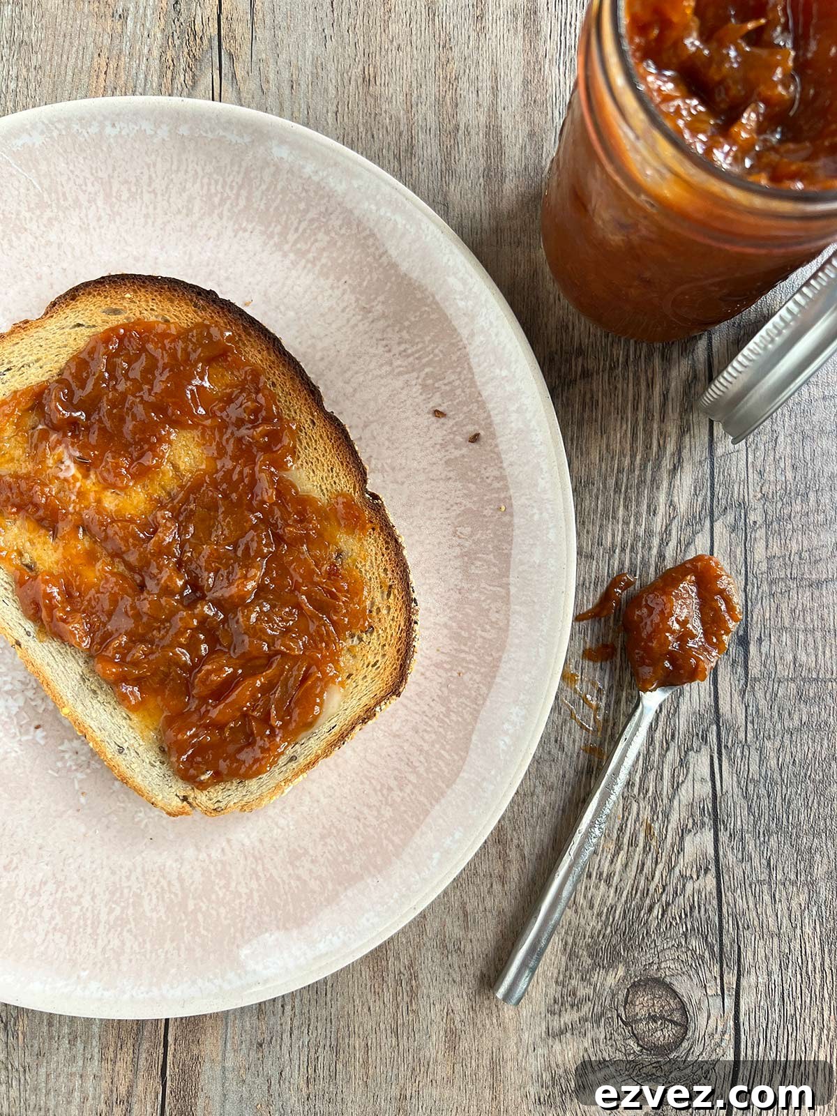 Apricot jam on toast with a spoon of the jam on the side.