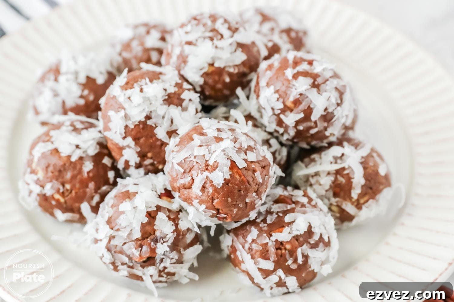 A plate filled with chocolate Amaretto balls coated in shredded coconut, neatly arranged and ready to serve.
