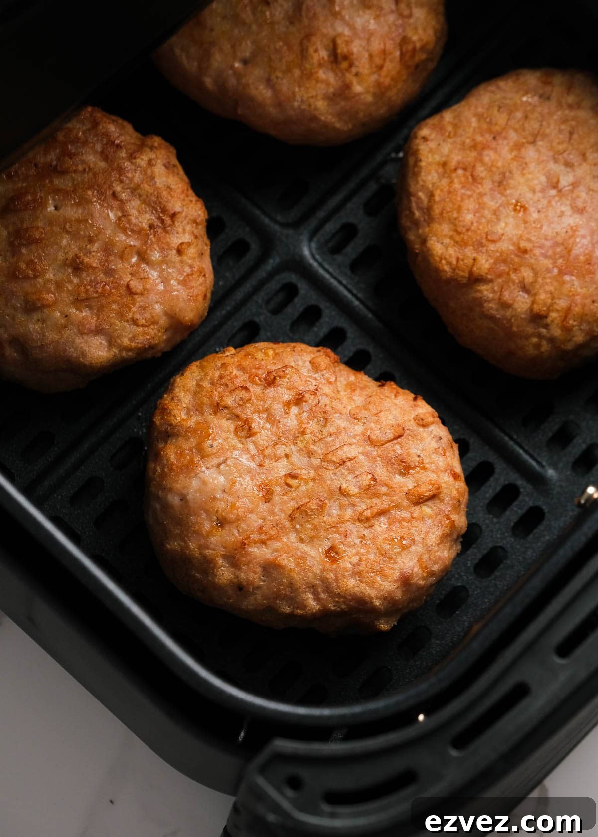 cooked turkey burger patty in an air fryer basket