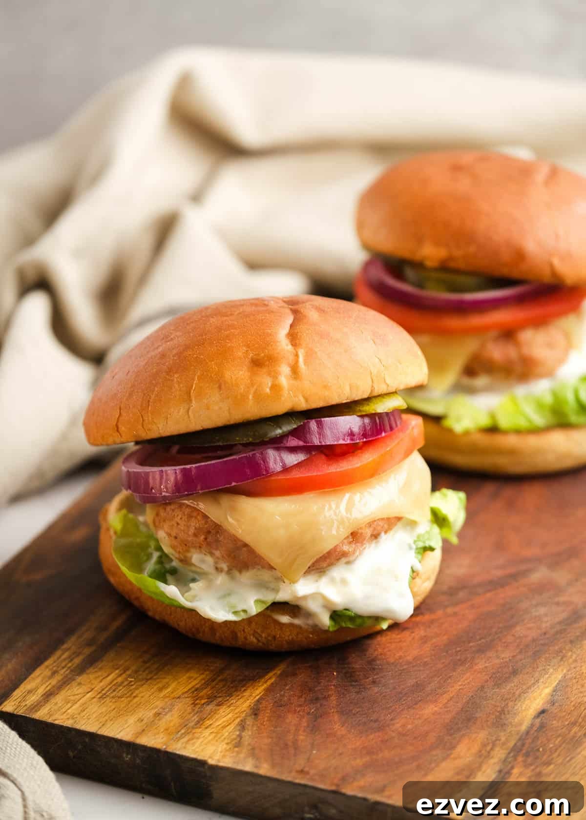 far-away shot of two loaded turkey burgers on a cutting board