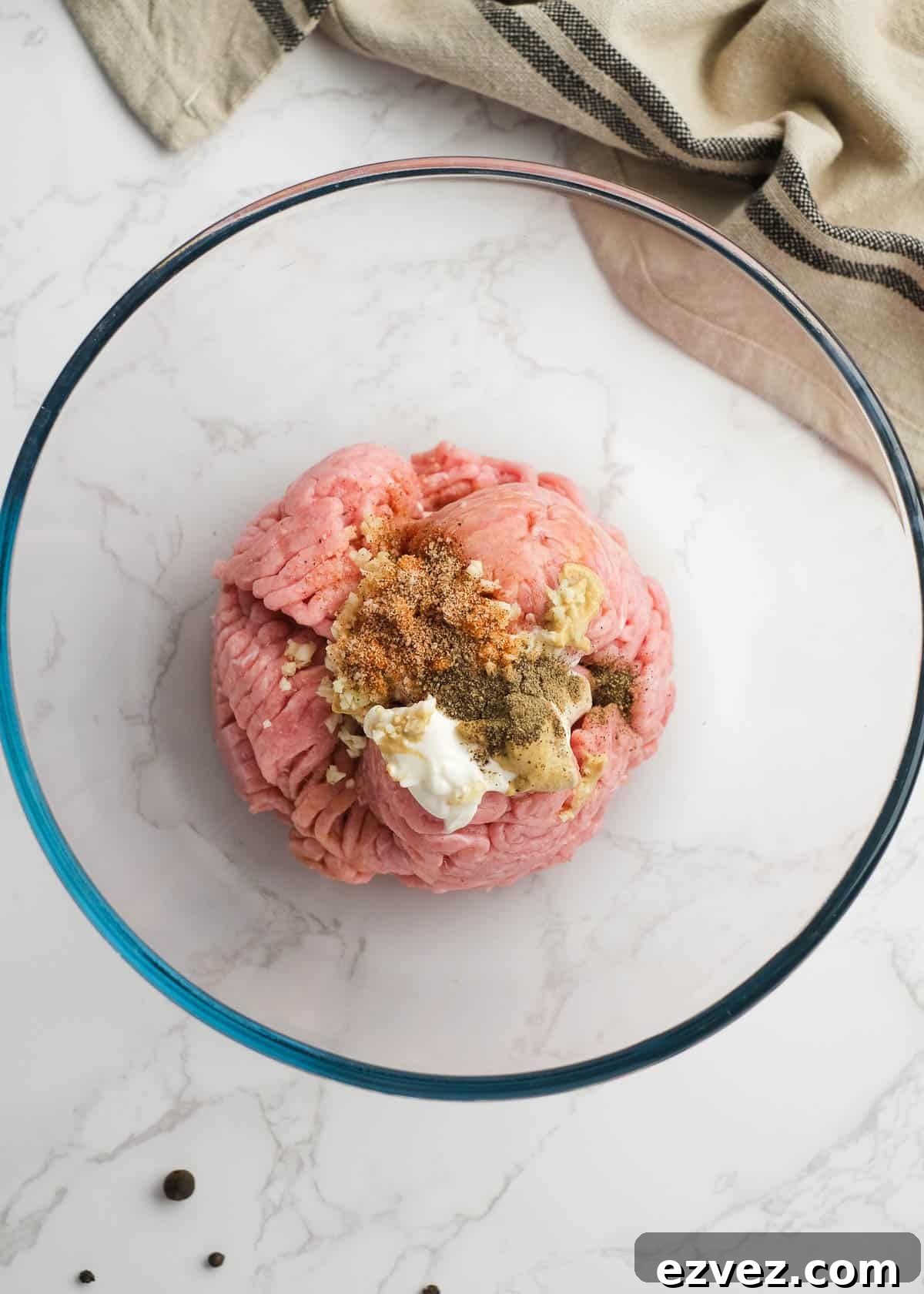 ground turkey with mayonnaise and seasonings in a glass bowl