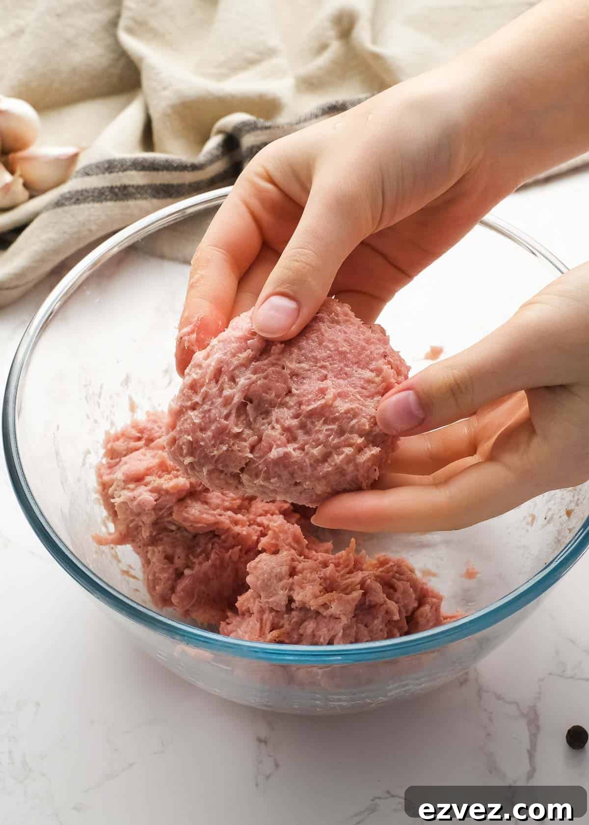 hands forming burger patties with seasoned ground turkey