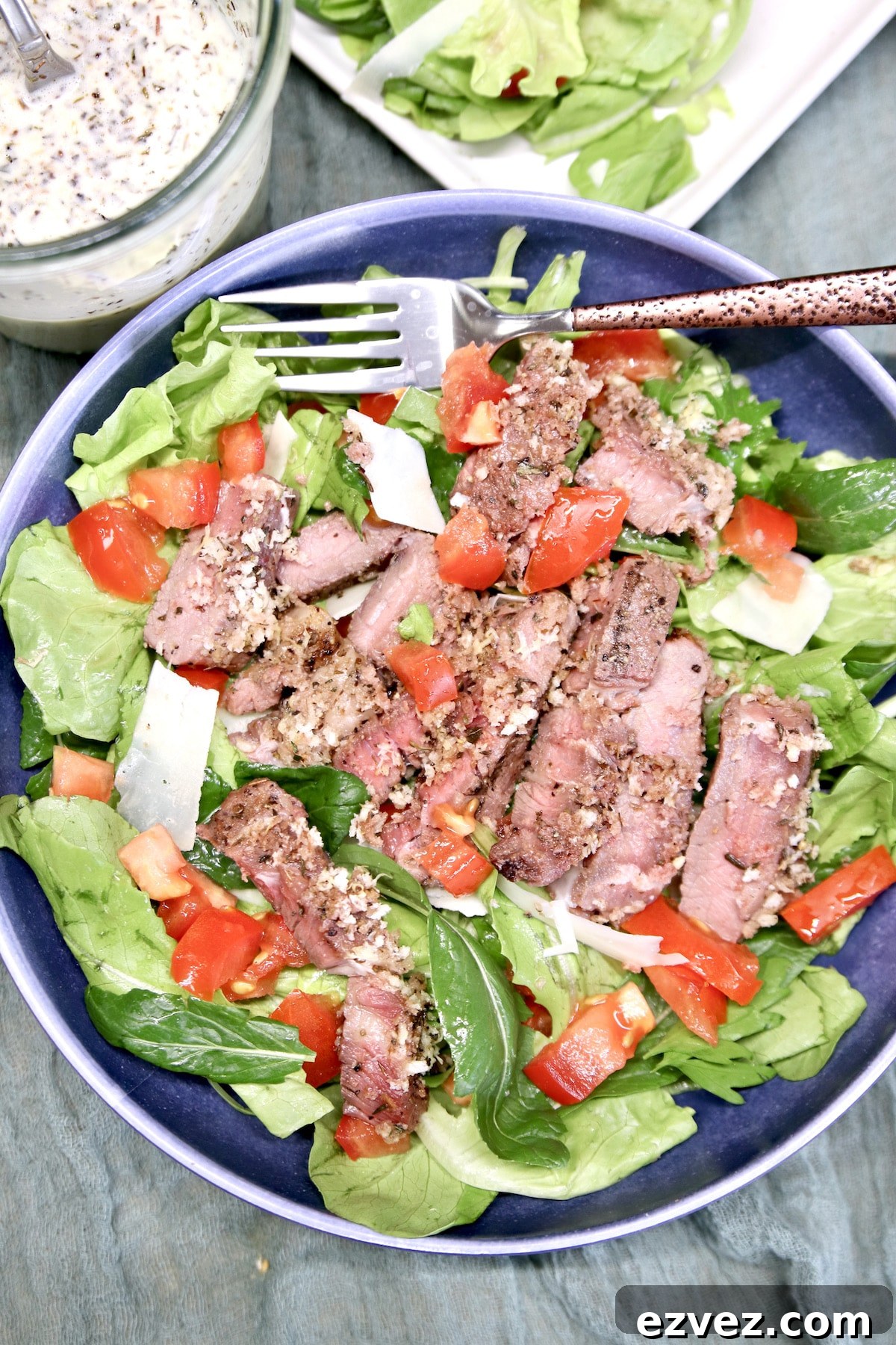 Grilled steak salad in a bowl with a fork.