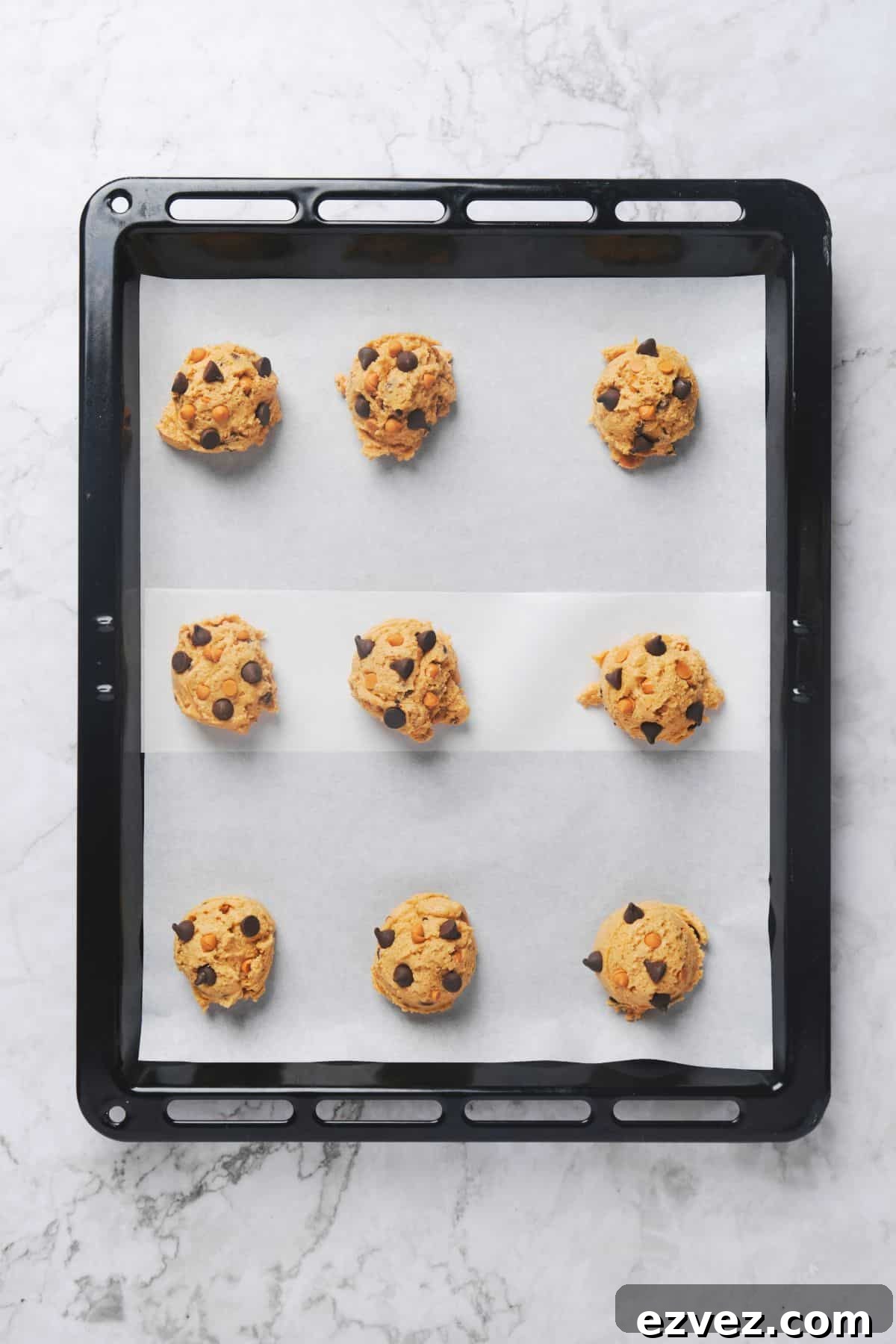 Chocolate chip butterscotch cookie balls on a cookie tray.